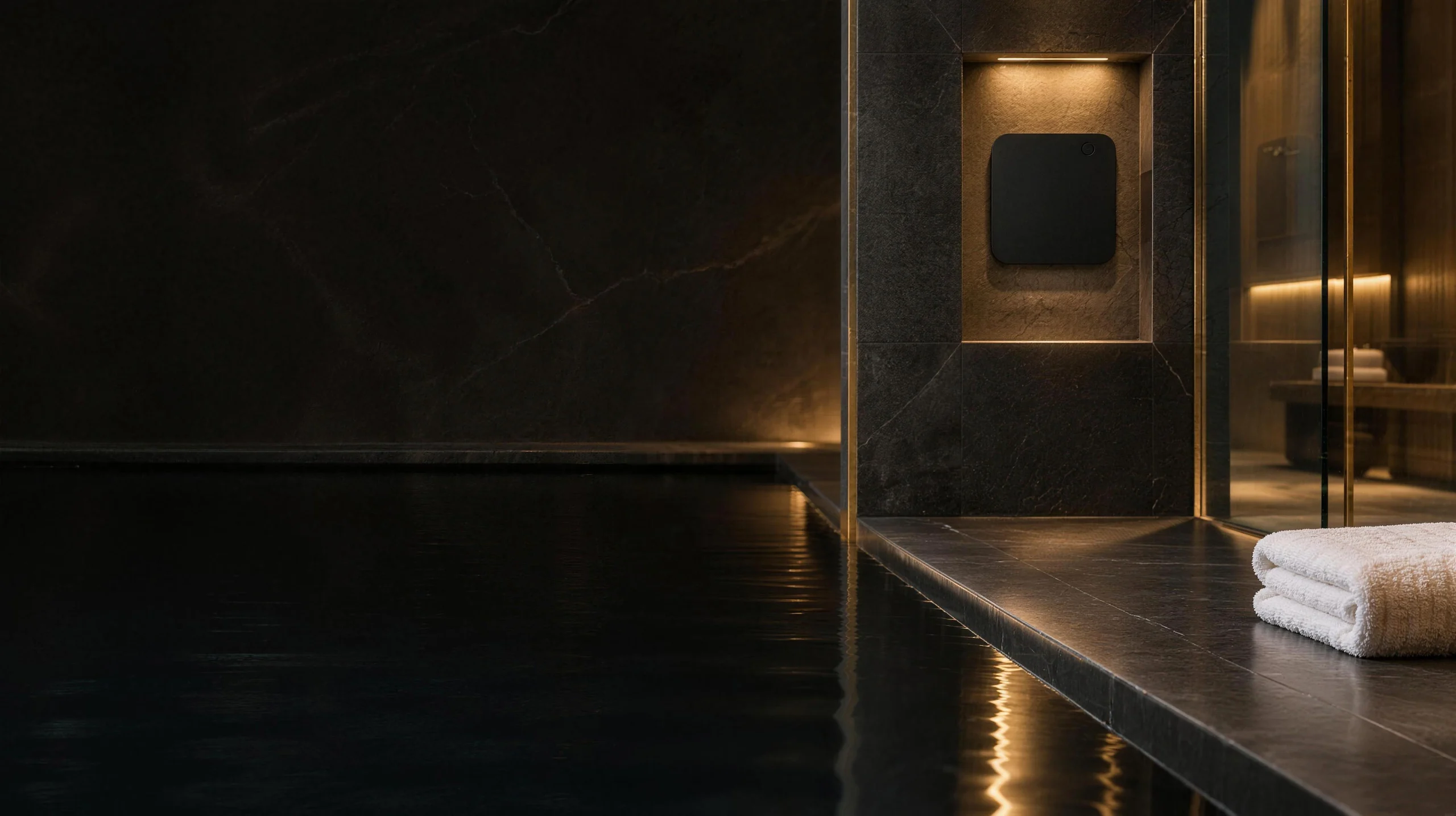 Spa d’hôtel, bassin d’eau calme et pierre sombre, diffuseur SILLAGE dans une niche