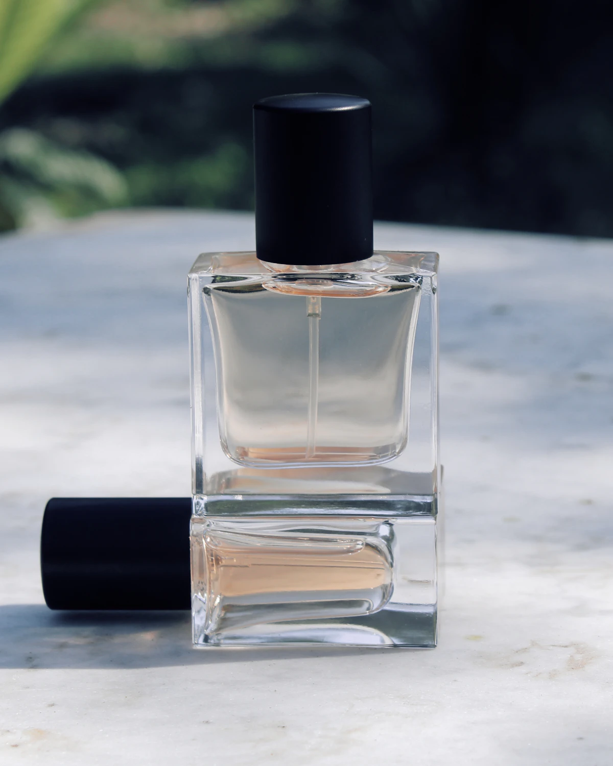 Flacon de parfum en verre posé sur le marbre, lumière douce